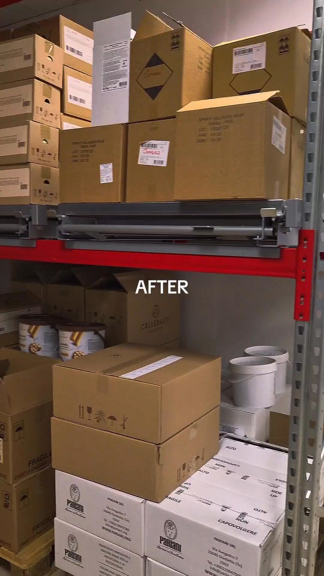 Cardboard boxes neatly stacked on metal warehouse shelves, with white buckets on the lower shelf.