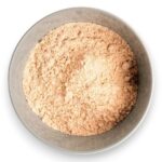 Top view of a round metal bowl filled with beige powdery substance.