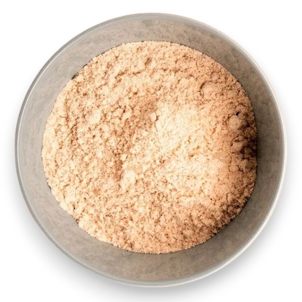 Top view of a round metal bowl filled with beige powdery substance.